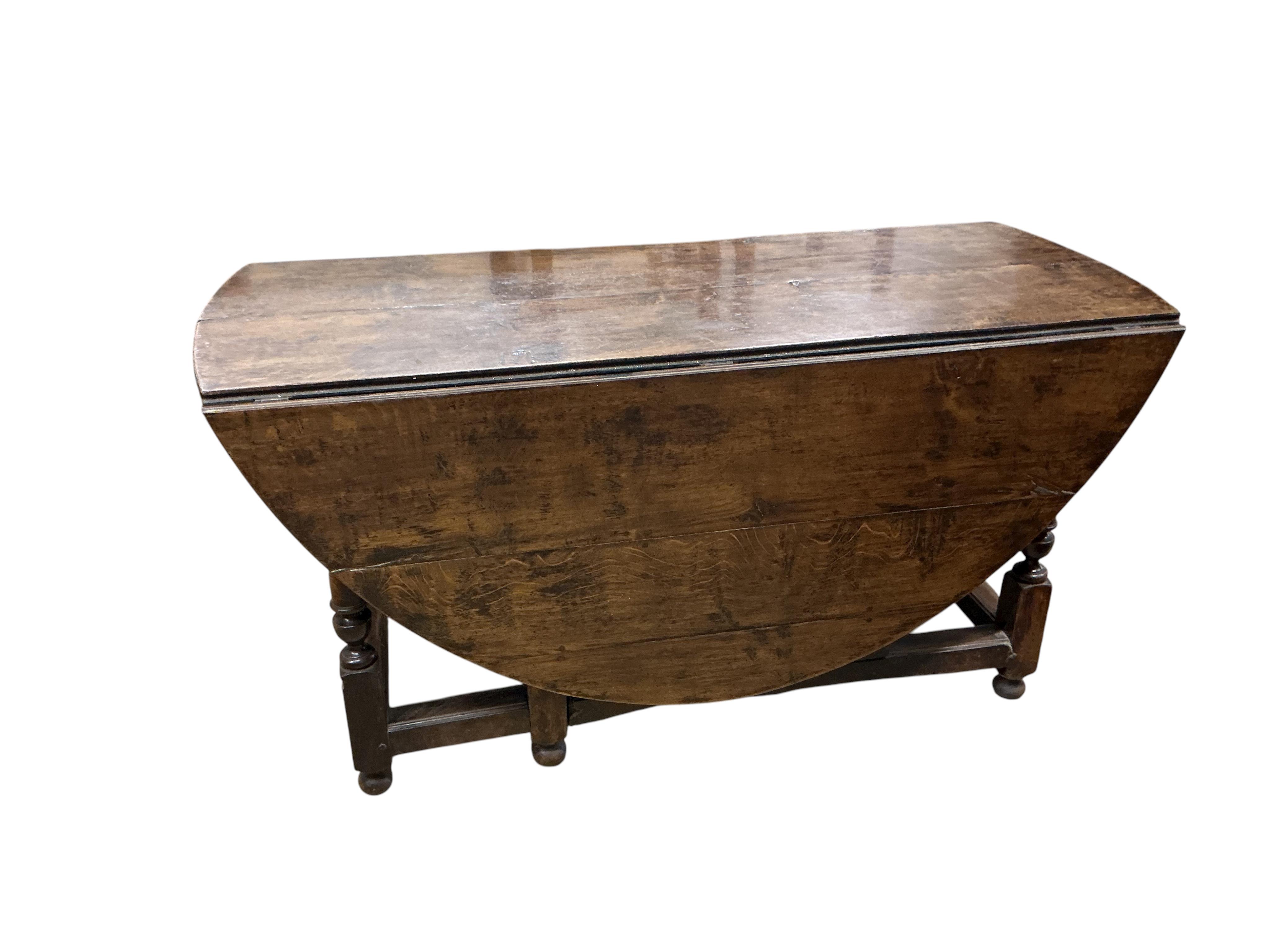 An early 17th century style oak gateleg dining table incorporating earlier elements, width 151cm, depth 62cm, height 75cm